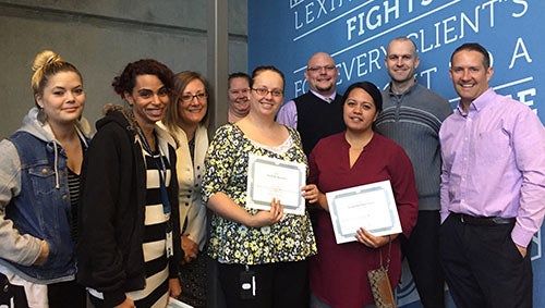 Lexington Law paralegals smiling in front of company sign