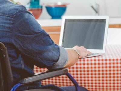 person in a wheelchair on a laptop