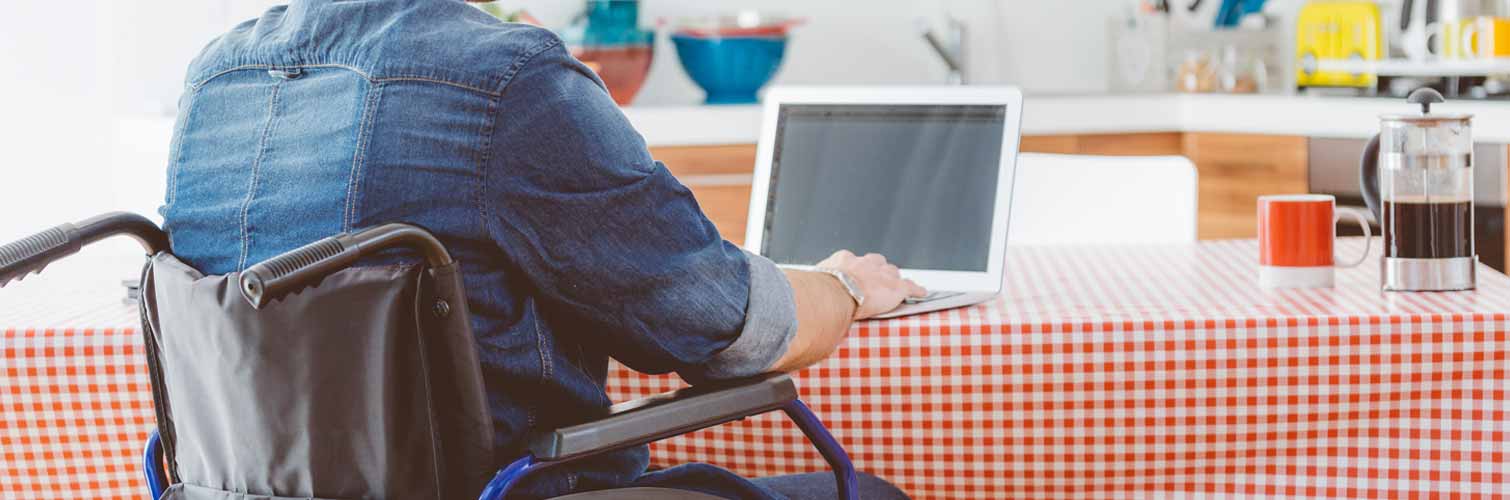 person in a wheelchair on a laptop