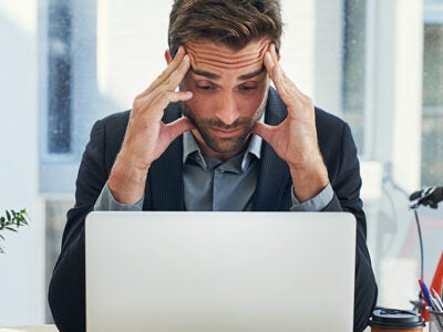 Stressed man looking at computer