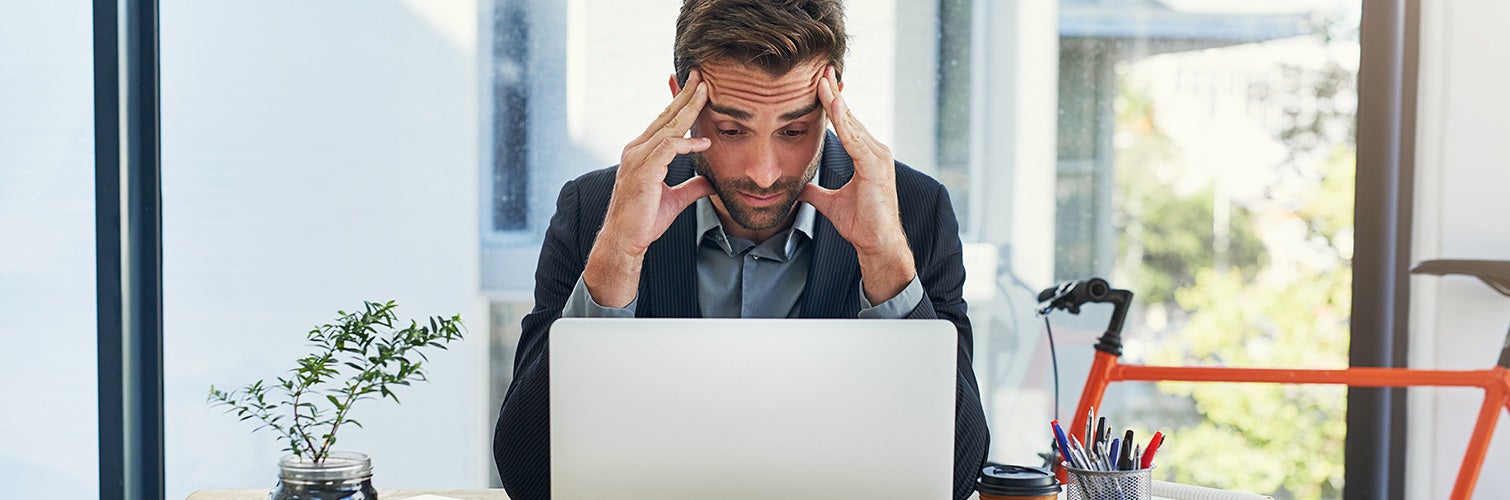 Stressed man looking at computer 