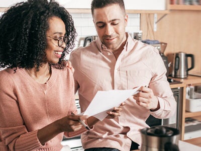 couple looking over bills gleefully