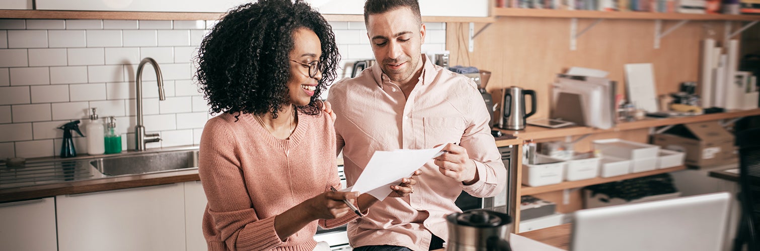 couple looking over bills gleefully