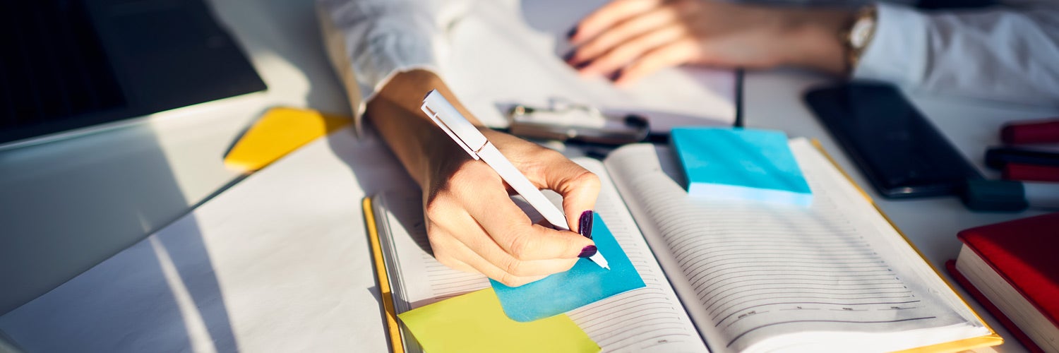 A person writing notes in a planner