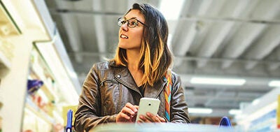 gen z girl shopping in grocery store with smartphone