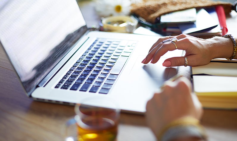 A woman typing on a keyboard