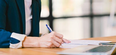 man sitting at desk signing papers