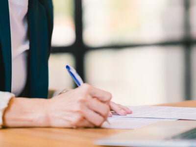 man sitting at desk signing papers