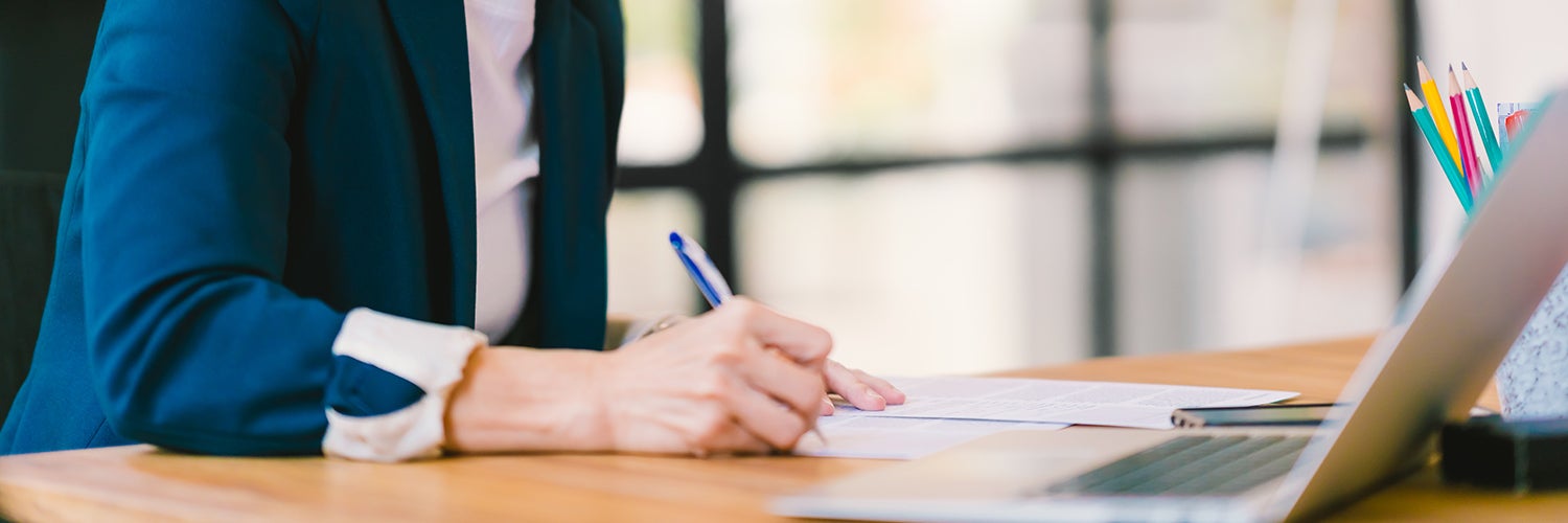 man signing papers at a desk