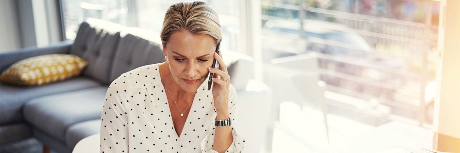 mujer en el teléfono preguntando por qué su puntaje de crédito baja