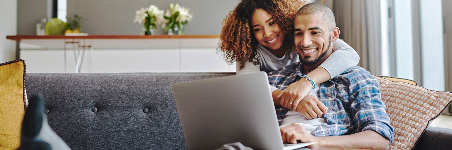 Photo: couple smiling looking at laptop
