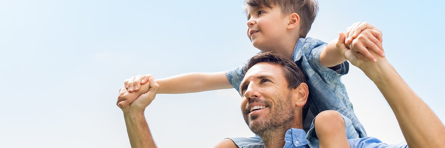 A father holding his son on his shoulders.