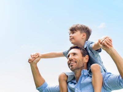 A father holding his son on his shoulders.