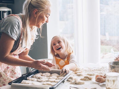 A mother and daughter cook together in the kitchen.