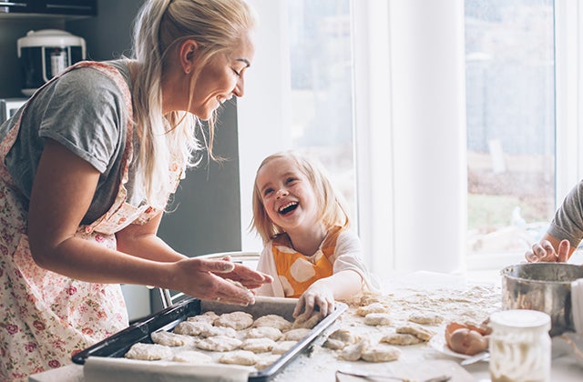 A mother and daughter cook together in the kitchen.