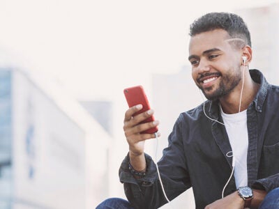 Man looking at his phone while wearing earphones