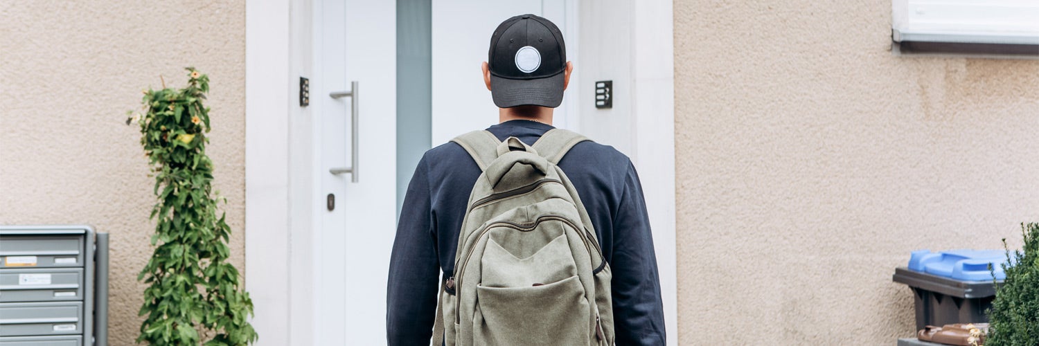 Man with backpack standing at door.