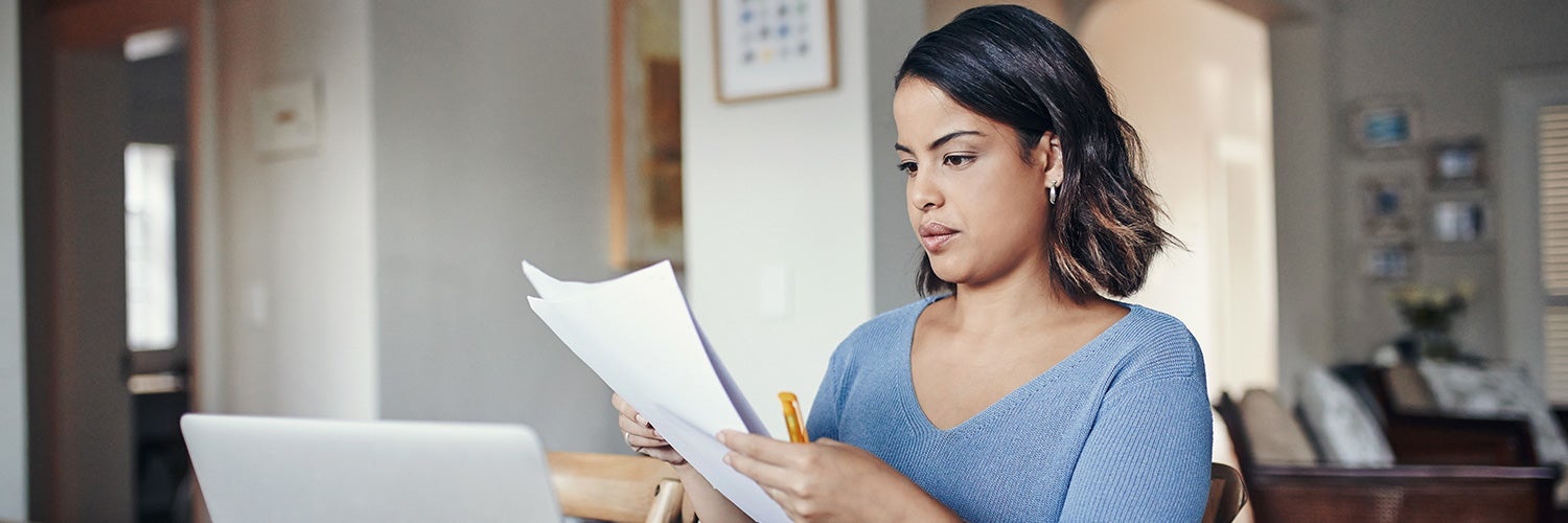 woman looking holding and looking at papers.