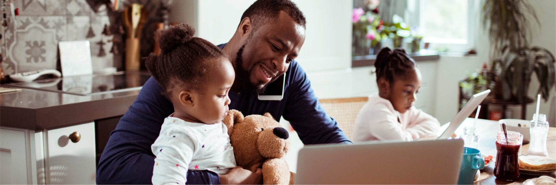 Man and daughter sit in front of a laptop.