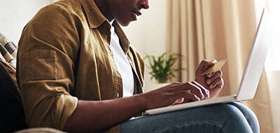 Man using credit card to make online purchase.