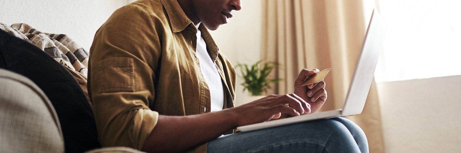 Man using credit card to make online purchase.