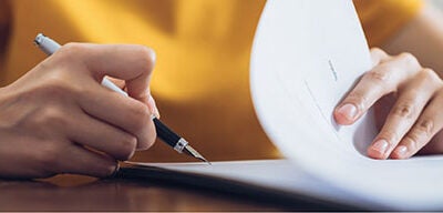 Person filing a credit dispute by filling out paperwork.