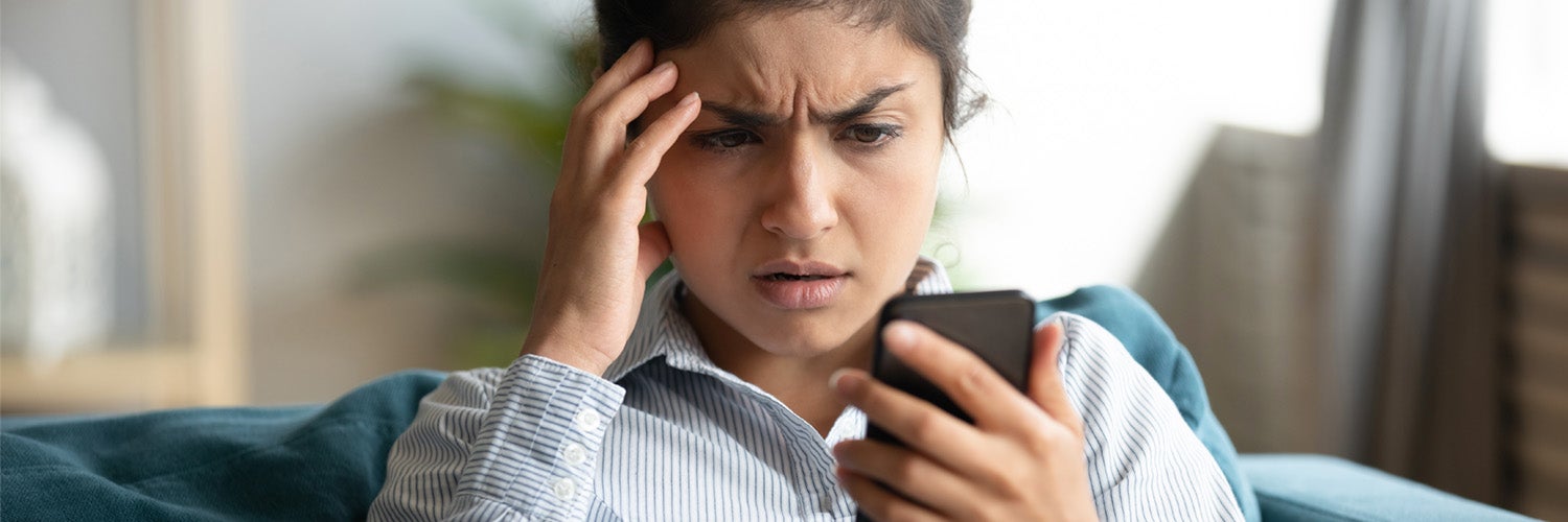 Woman staring perplexed at her phone.